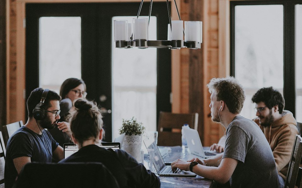 Klein team overlegt aan een tafel op kantoor