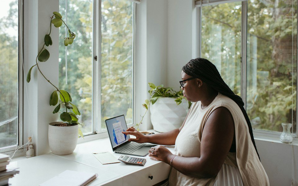 Zzp-er werkt op een laptop bij het raam